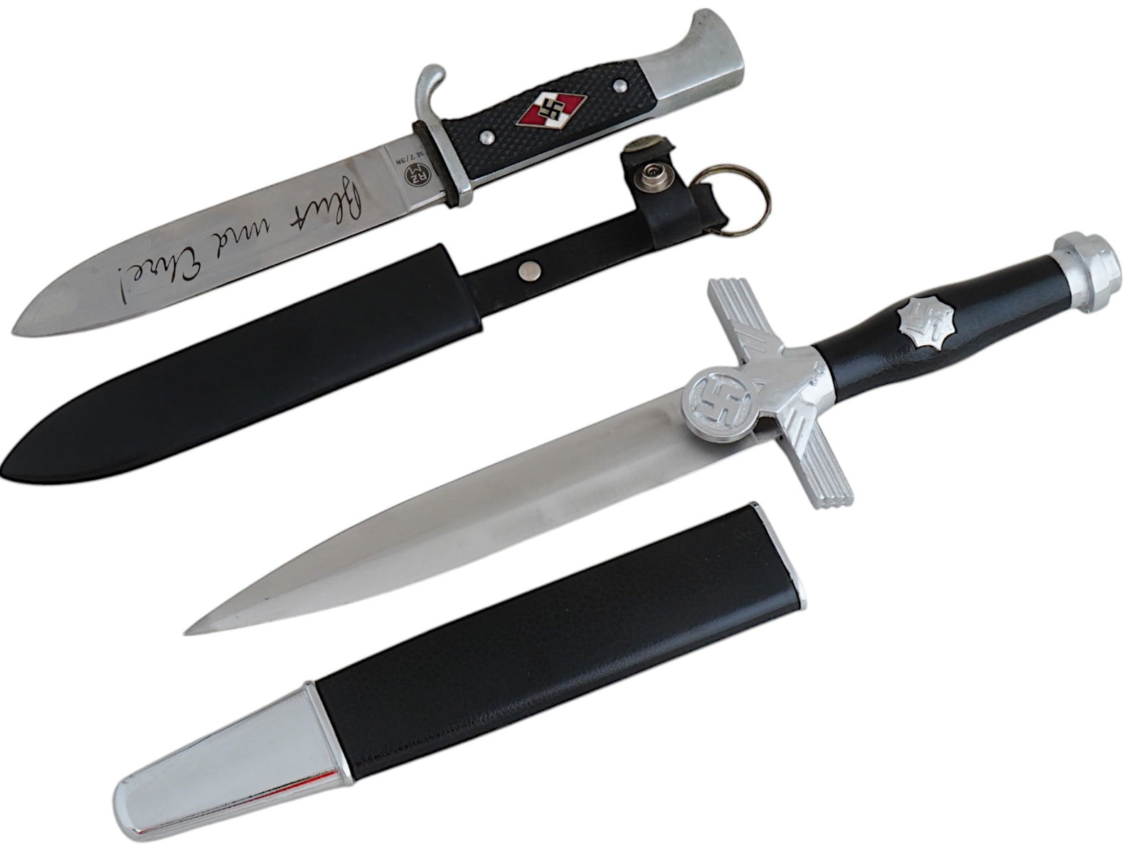 LOT OF WWII NAZI GERMAN THIRD REICH MODEL DAGGERS: A lot of two WWII Nazi German Third Reich model daggers. The first: a Hitler Youth members dagger with a black painted magnetic sheet steel scabbard. The black bakelite grip has an enameled diamond wi