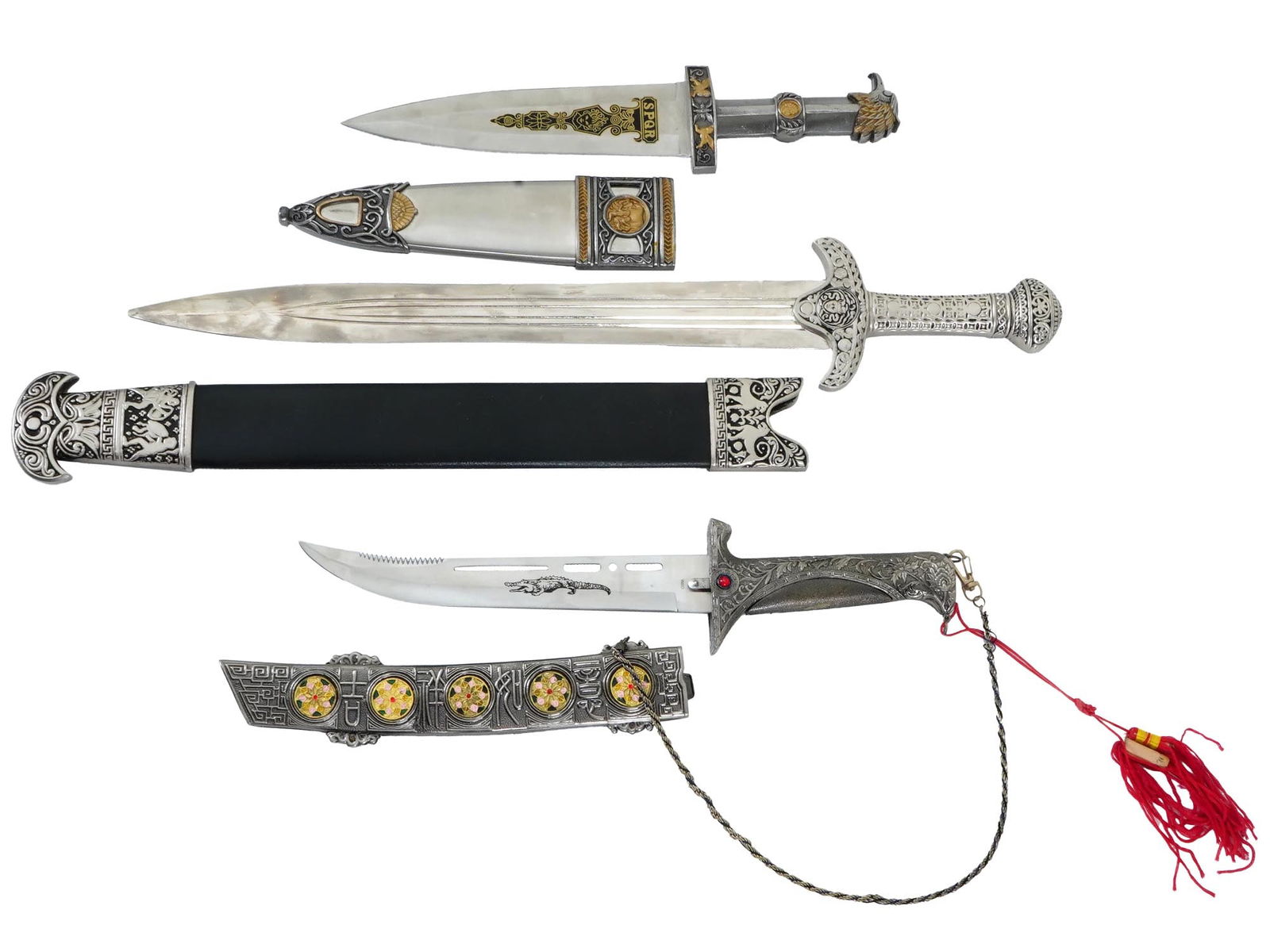 GROUP OF DECORATIVE HISTORICAL STYLE DAGGERS AND SWORDS: A group of three decorative historical-style daggers and swords. The first is a Roman dagger featuring a steel blade etched with the inscription SPQR and a pommel shaped like an eagle, complete with a