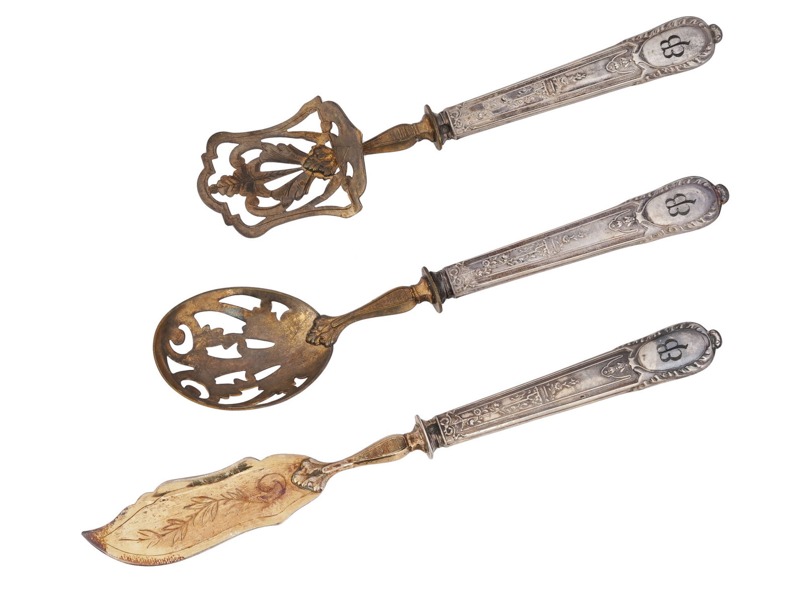 WWII EVA BRAUN MONOGRAMMED DESSERT SERVING SET: A WWII German Eva Braun dessert serving set, including a highly decorative spatula, spoon, and knife. Each item is garnished with engraved initials E B on the handle tips, referring to Eva Braun, 1912