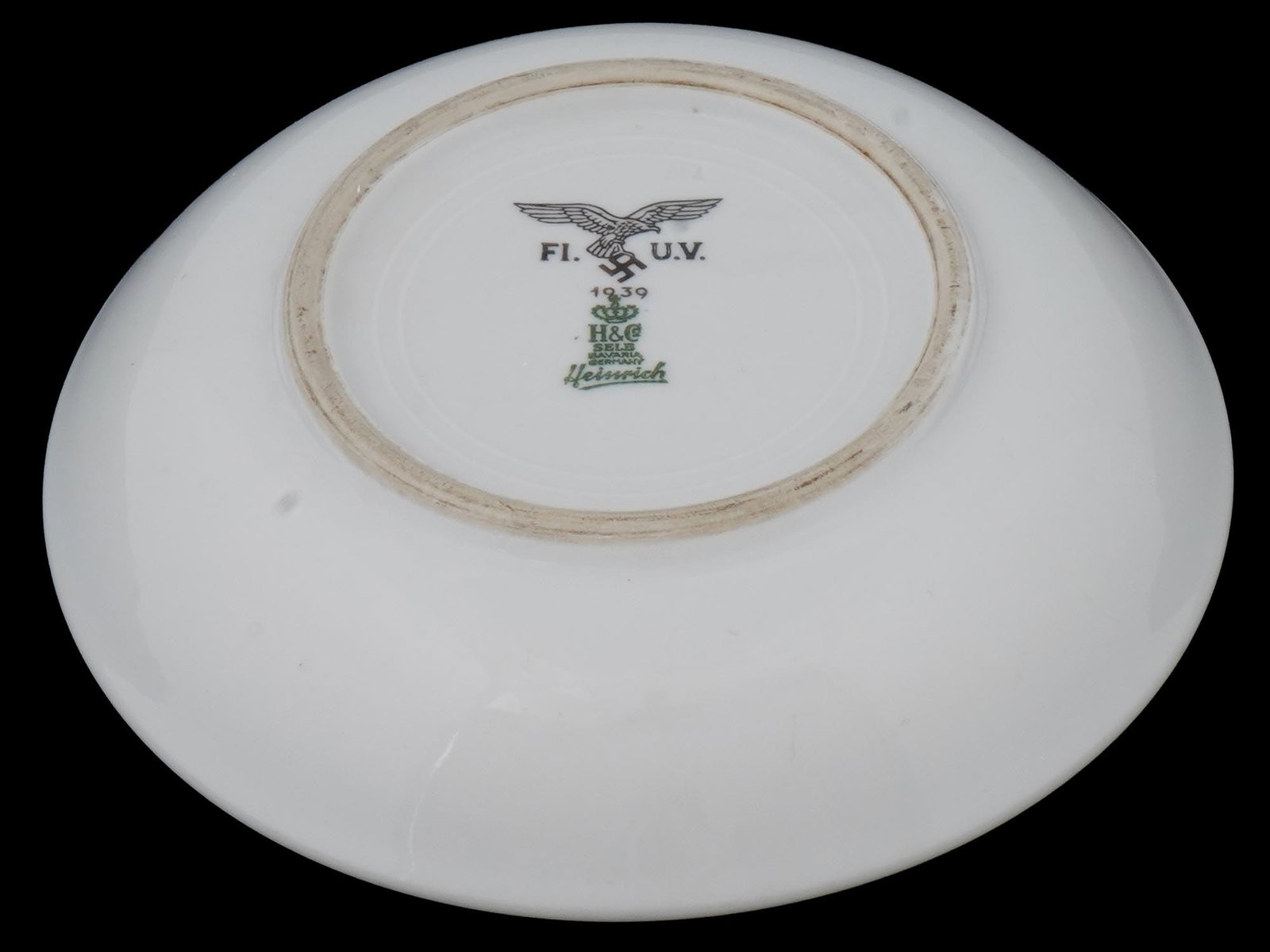 WWII GERMAN LUFTWAFFE KANTINEN PORCELAIN PLATE: A WWII German 3rd Reich Luftwaffe Kantinen white porcelain plate. The piece is marked on the bottom: Reichsadler with swastika, 1939, lettering Fl. U.V. Flieger Unterkunfts Verwaltung, and the logo of