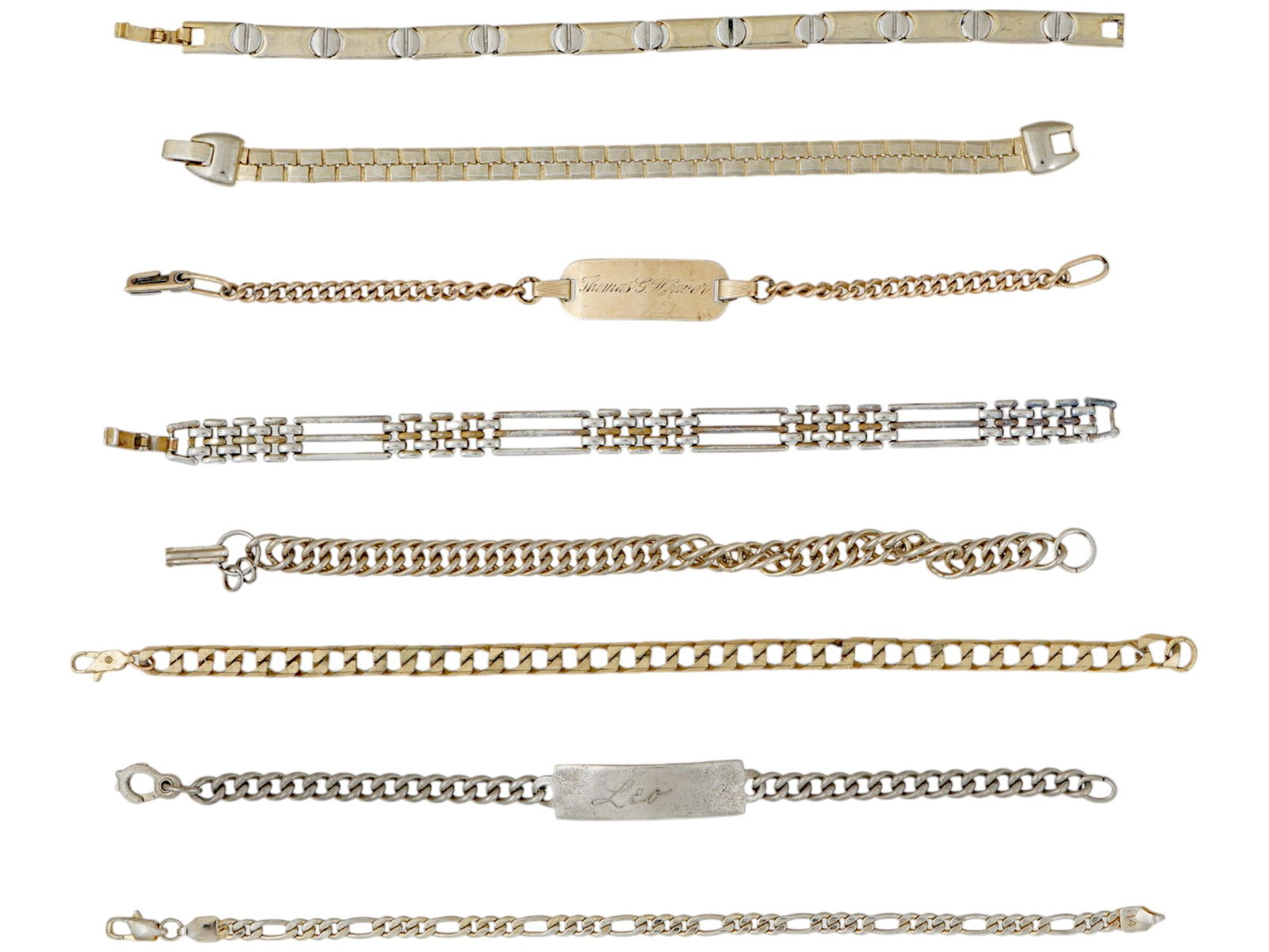 ASSORTMENT OF EIGHT CHAIN LINK BRACELETS: An assortment of eight chain link bracelets. Several of the bracelets are gold toned and silver toned. Two of the bracelets include a rectangular metal plaque with engraved initials and numerals. One