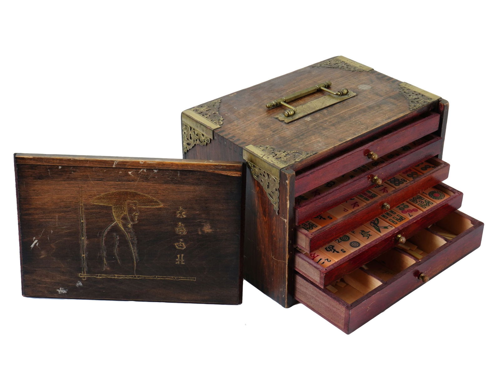 ANTIQUE CHINESE MAHJONG GAME SET IN HARDWOOD CASE: An antique Chinese mahjong game set. The game is stored in a hardwood case with a dark stain and decorative brass corner pieces with brass handles. The case has multiple drawers, revealing the bone an
