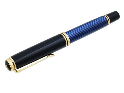GERMAN PELIKAN M805 18K GOLD SOUVERAN FOUNTAIN PEN: A German Pelikan M805 Souveran fountain pen. Piston filling system. Blue lined barrel with semi transparency. Black cap. Silver colored rhodium plated trim. 18K Gold two tone nib. Marked, 18C 750 BB,