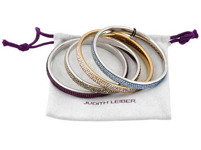 LOT OF AMERICAN JUDITH LEIBER CRYSTALS BRACELETS: A collection of four American slim shimmy thin pave bangle bracelets by Judith Leiber Jewelry. The bracelets are encrusted with purple, beige, gold, and blue cut Swarovski Crystals. Each is marked wit