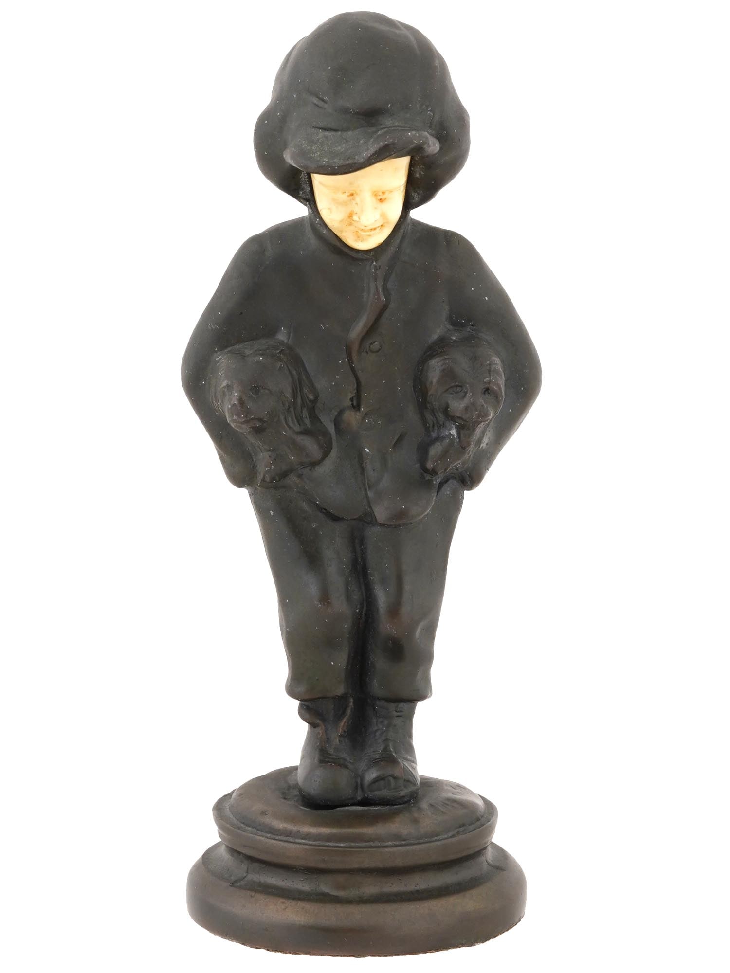 ANTIQUE ART DECO PATINATED BRONZE FAUX BONE FIGURINE: An antique Art Deco patinated bronze and faux bone figurine. Circa early 20th century. The figurine depicts a walking boy with two puppies in his hands. The sculpture is raised on a round base. Protec