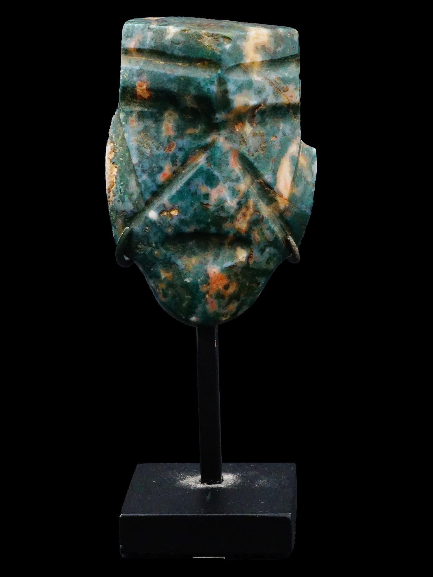 ANCIENT PRE COLUMBIAN AMERICA JADE OLMEC MASK: An ancient Olmec mask from Pre Columbian America made of jade. The male mask has harshly carved facial features. Comes with a stand. The Olmecs flourished during Mesoamericas formative period, dating