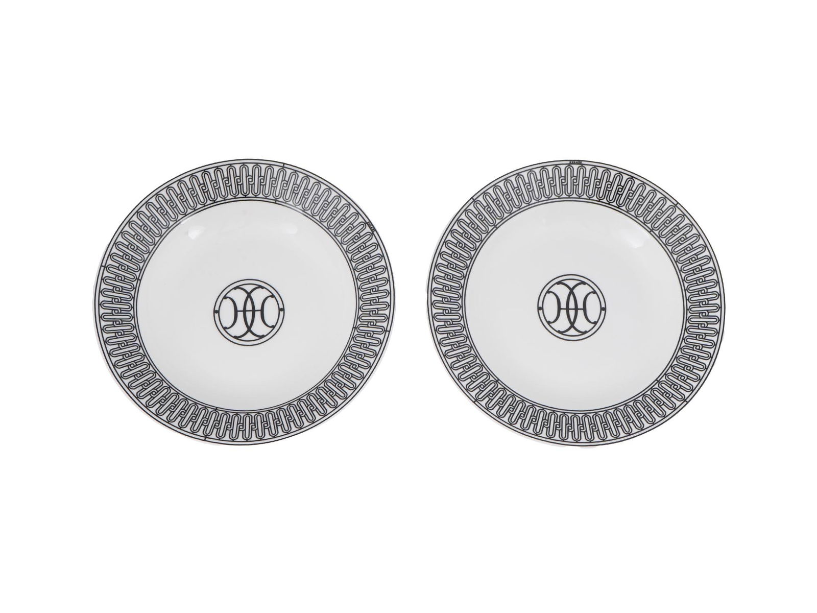 VINTAGE HERMES H DECO WHITE PORCELAIN SOUP PLATES: A pair of vintage porcelain soup plates by Hermes. H Deco collection. Screen-printed black and white ornament. Hallmarked on the bottom. Inspired by the Art Deco ironwork of Hermes Parisian stores, th
