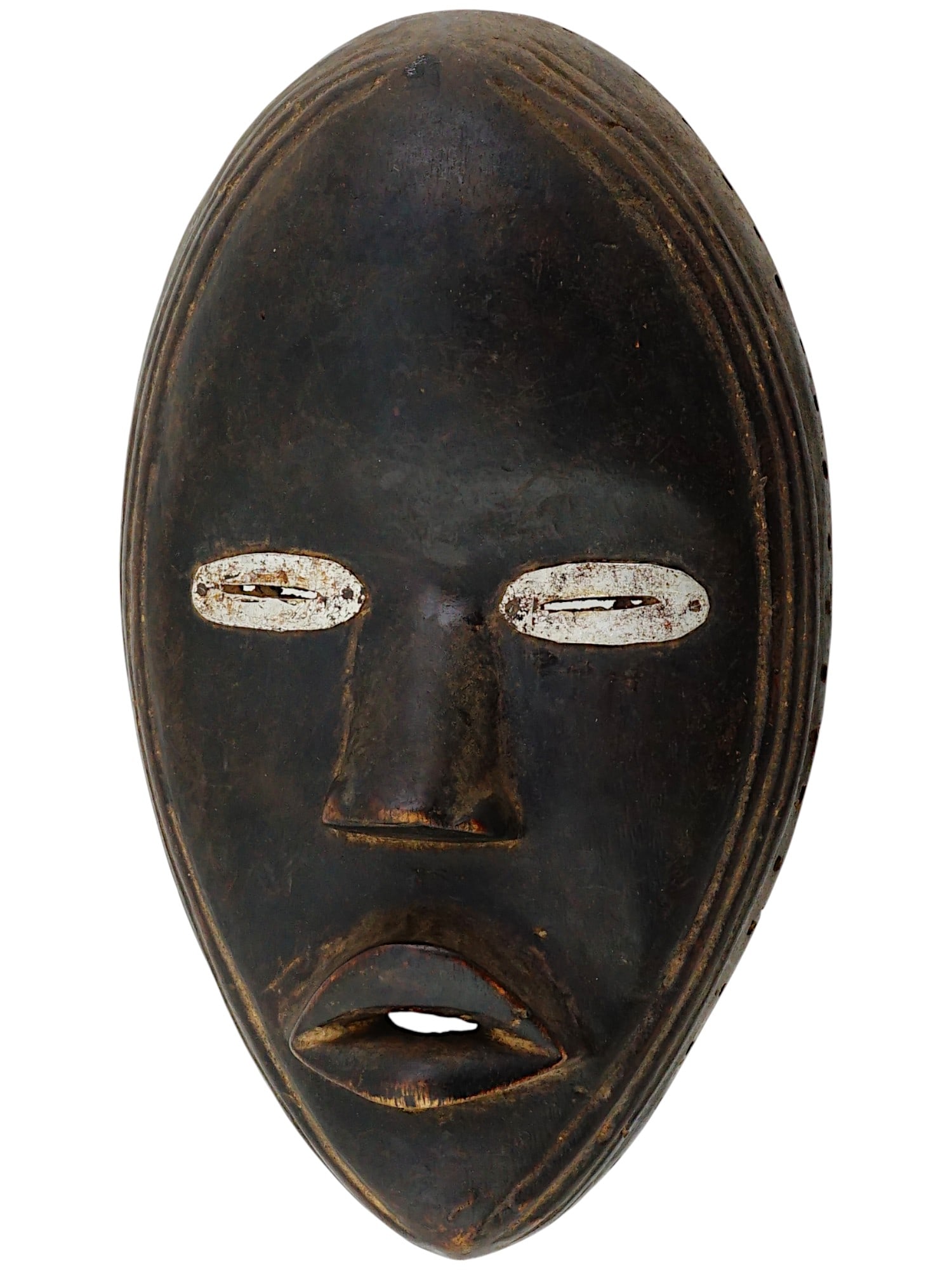 AFRICAN IVORY COAST MANDE DAN CARVED WOOD MASK: An African hand carved wood tribal mask of the Dan people, a Mande ethnic group from northwestern Ivory Coast and neighboring Liberia. They are officially known as Yacouba in Ivory Coast. The oval fac