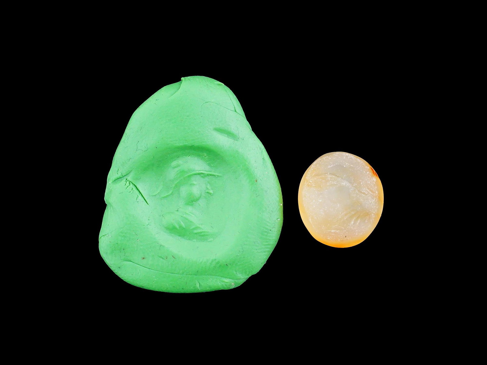 CARVED STONE INTAGLIO ANCIENT ROMAN MALE PORTRAIT: A carved stone intaglio featuring an ancient Roman portrait of a male figure, in profile. Such intaglios were used as personal seals, amulets, or decorative jewelry, showcasing the Romans appreciation