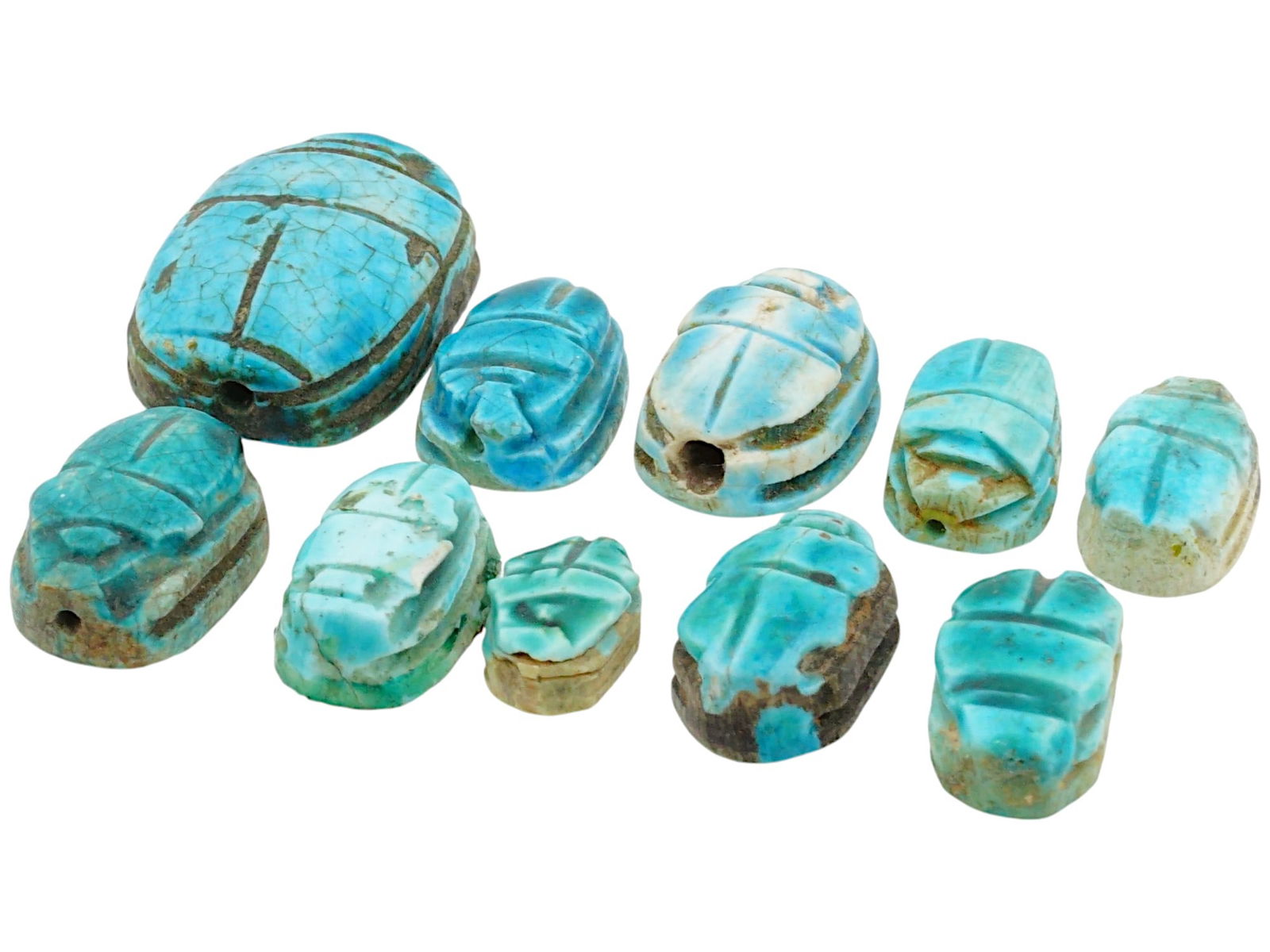 EGYPTIAN GRAND TOUR BLUE FAIENCE SCARAB AMULET BEADS: A collection of 10 antique Egyptian Grand Tour blue faience scarab amulet beads, adorned with letters, images and stripes on the underside. Scarabs, symbolic of renewal and protection, were highly val