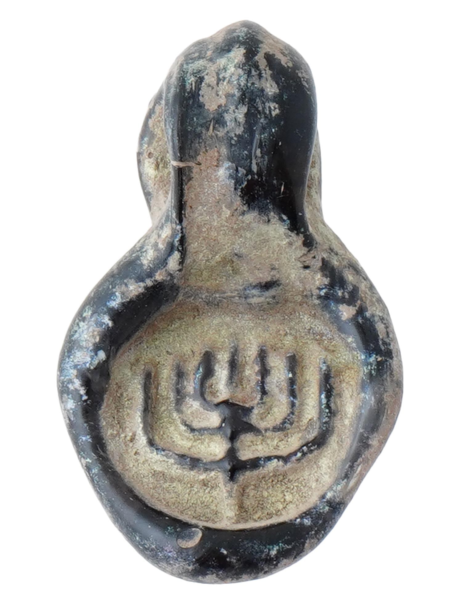 ANCIENT ROMAN PERIOD HOLY LAND GLASS MENORAH PENDANT: An ancient Roman Period Holy Land glass pendant adorned with a raised image of a menorah. Worn as a pendant, the menorah was often thought to protect its owner and bring luck. Circa 100 AD. Ancient Ho