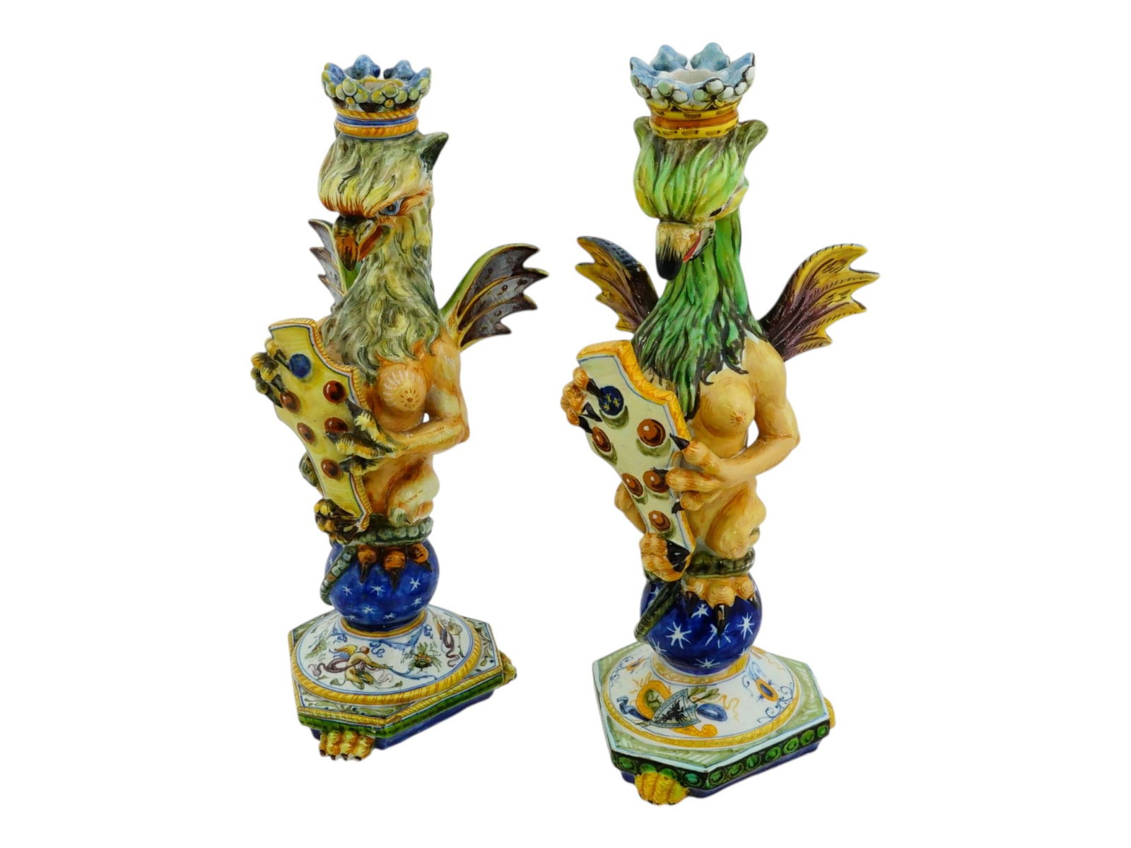 VINTAGE ITALIAN MAJOLICA GRIFFINS CANDLESTICKS: A pair of vintage Italian hand painted majolica terracotta sculpted candlesticks. The candlesticks are modeled in the form of crowned standing griffins holding coats of arms in their talons. Each item
