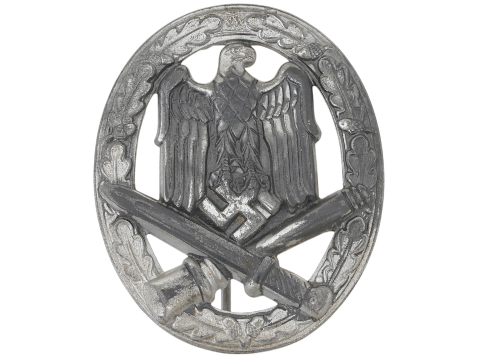 WWII TYPE GERMAN MILITARY GENERAL ASSAULT BADGE: A WWII type General assault badge designed with an eagle holding a swastika above a crossed bayonet and grenade, surrounded by an oak leaf wreath. Unmarked. Second World War Historical Collectables An