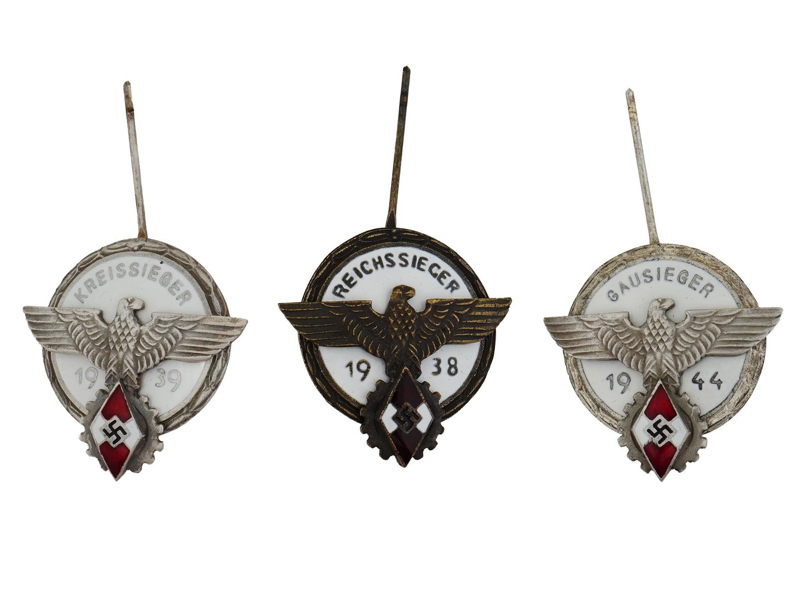 WWII MODEL GERMAN HITLER YOUTH SIEGER BADGES: A lot of three World War II type German enameled aluminum badges of the Hitlerjugend. The pins feature a Reichsadler with swastika and Hitler Youth emblem. Reichssieger 1938. Kreissieger 1939. Gausieg