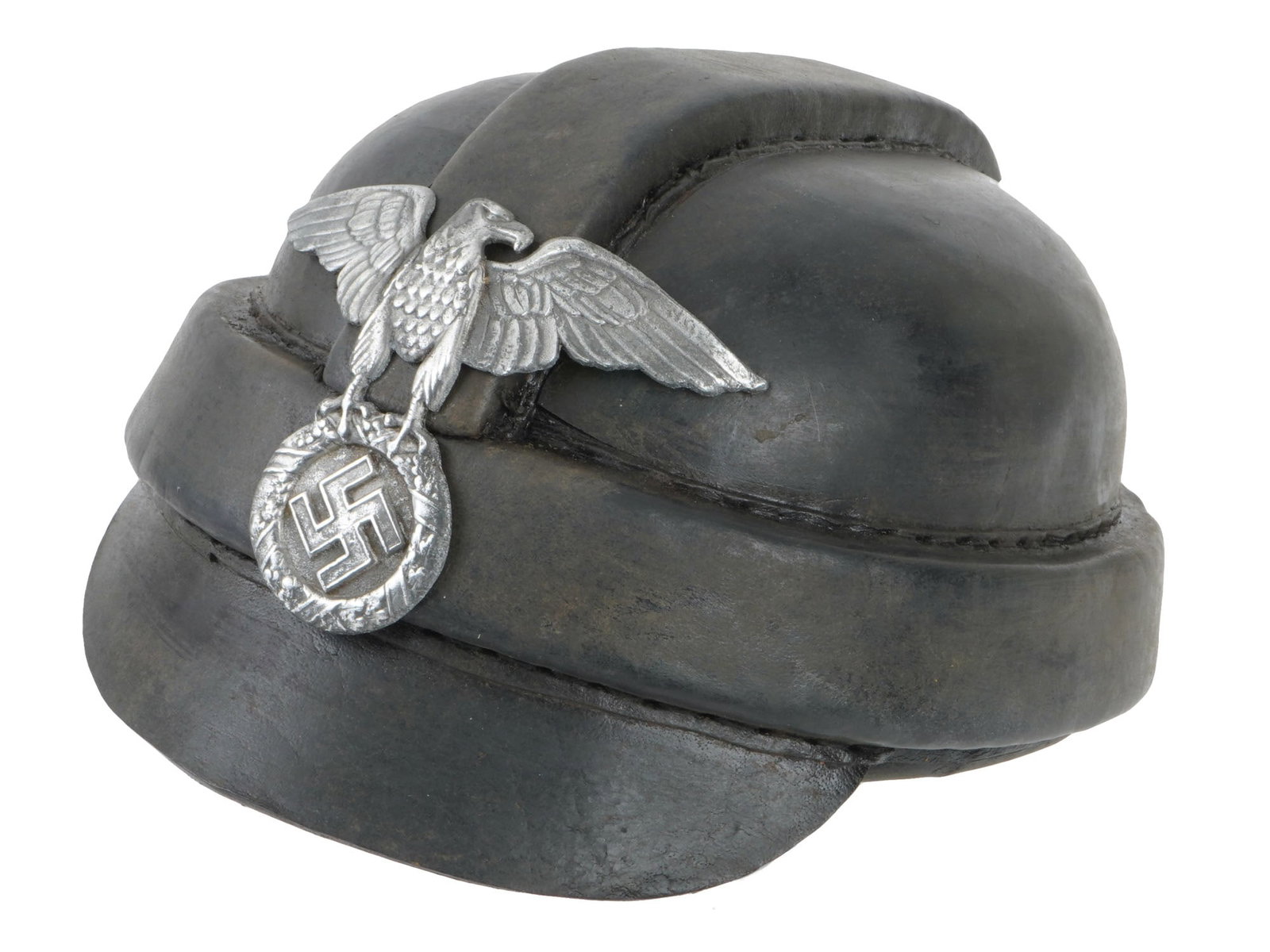 GERMAN WWII MODEL NSKK MOTORCYCLIST HELMET: A WWII Nazi German model NSKK motorcyclist helmet. The helmet is adorned with a metal sign representing a Nazi eagle clutching a swastika insignia, on the front. A leather lining. Marked with a stamp,