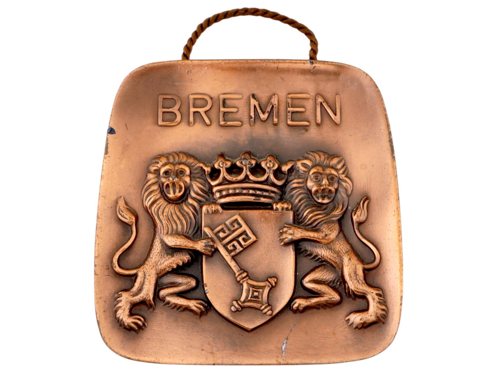 GERMAN BREMEN NAZI PARTY METAL WALL PLAQUE: A German Bremen Nazi Party metal wall plaque. The plaque features two lions standing on either side of a shield with a key, and a crown positioned above the shield. The word BREMEN is raised at the to