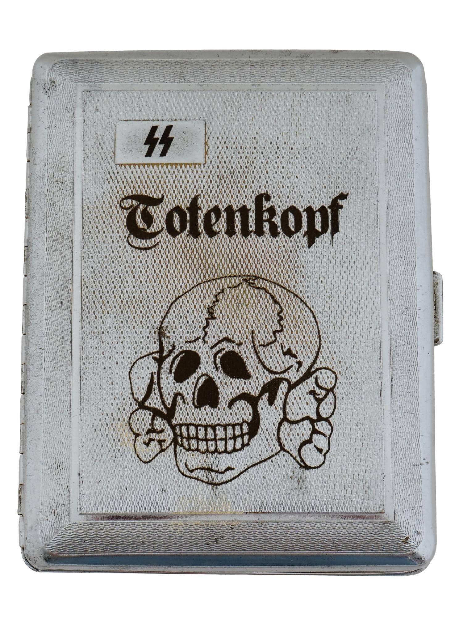 WWII TYPE NAZI GERMAN SS TOTENKOPF CIGARETTE CASE: A World War II type Nazi German cigarette case with a hinged cover featuring a skull emblem with SS runes. A Nazi eagle with a swastika on the back side. Two holder straps inside. Marked inside: SYLVA