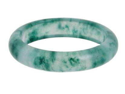 VINTAGE CHINESE CARVED NATURAL JADE BANGLE BRACELET: A vintage jade bangle bracelet, carved in a classic round shape from a single piece of natural jade. The bracelet features smooth, polished surfaces and a graceful silhouette, highlighting the stones