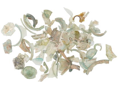 COLLECTION OF ANCIENT ROMAN GLASS FRAGMENTS: A collection of ancient Roman glass fragments. The shards exhibit varying degrees of translucency, with colors ranging from pale green and clear to amber. Museum Pieces, Ancient Roman Artefacts Collec