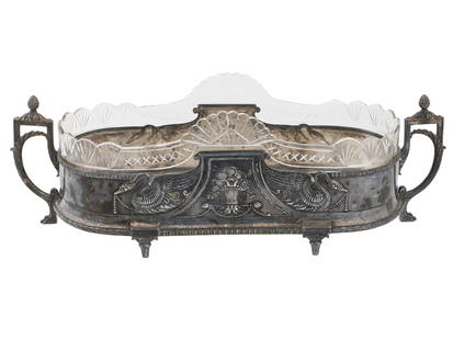 19TH CEN SILVER PLATED CENTERPIECE W CUT GLASS INSERT: An antique probably French footed silver plated centerpiece or jardiniere. The body is adorned with an engraved symmetrical composition depicting a vase with flowers to the center surrounded by swans