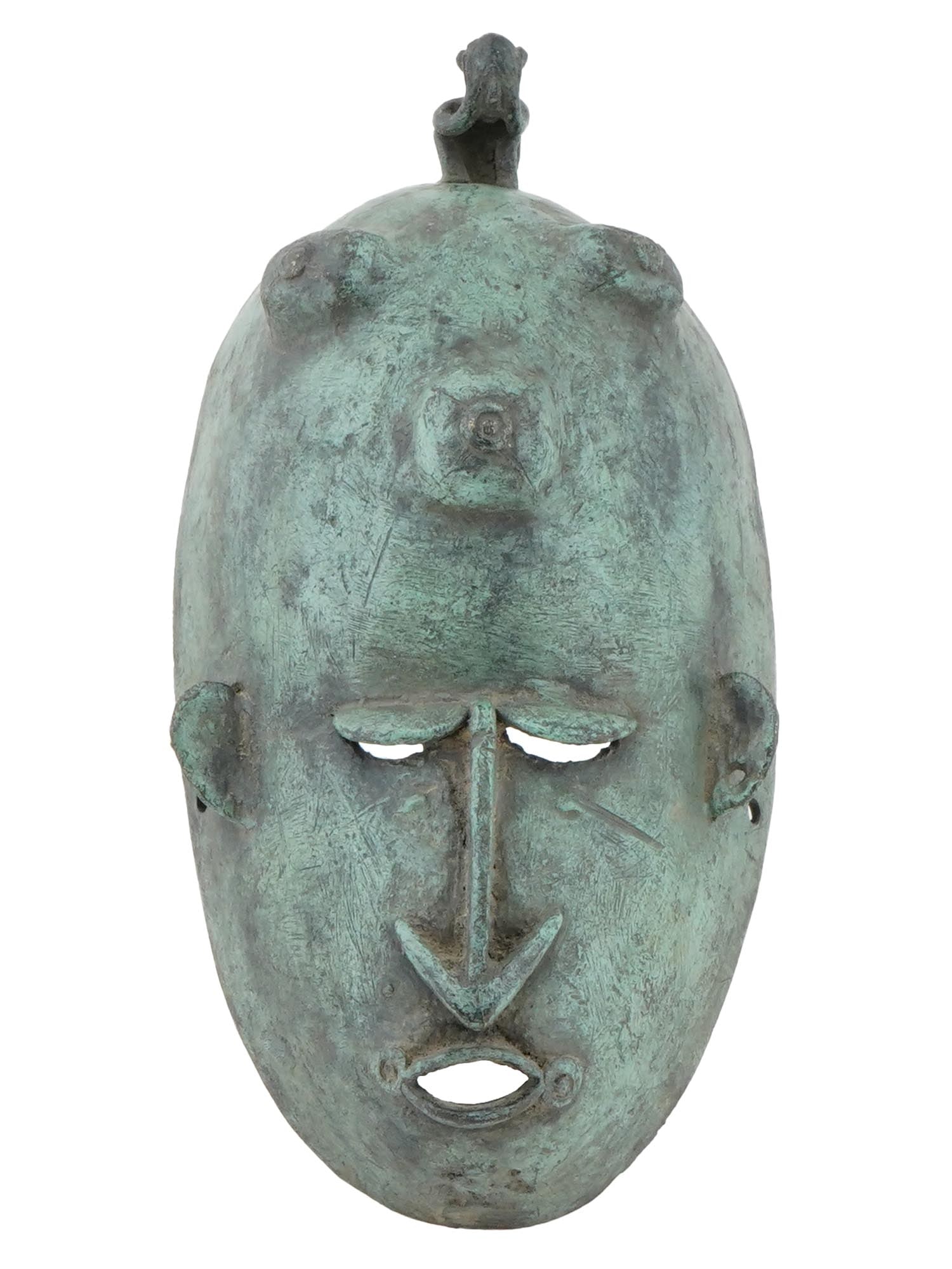 VINTAGE WEST AFRICAN DOGON TRIBE BRONZE SPIRIT MASK: A West African Dogon tribal spirit mask. The mask is adorned with a pair of openwork eyes, an open mouth, and a pair of accented ears, adorned with engraved facial features. The mask is adorned with a