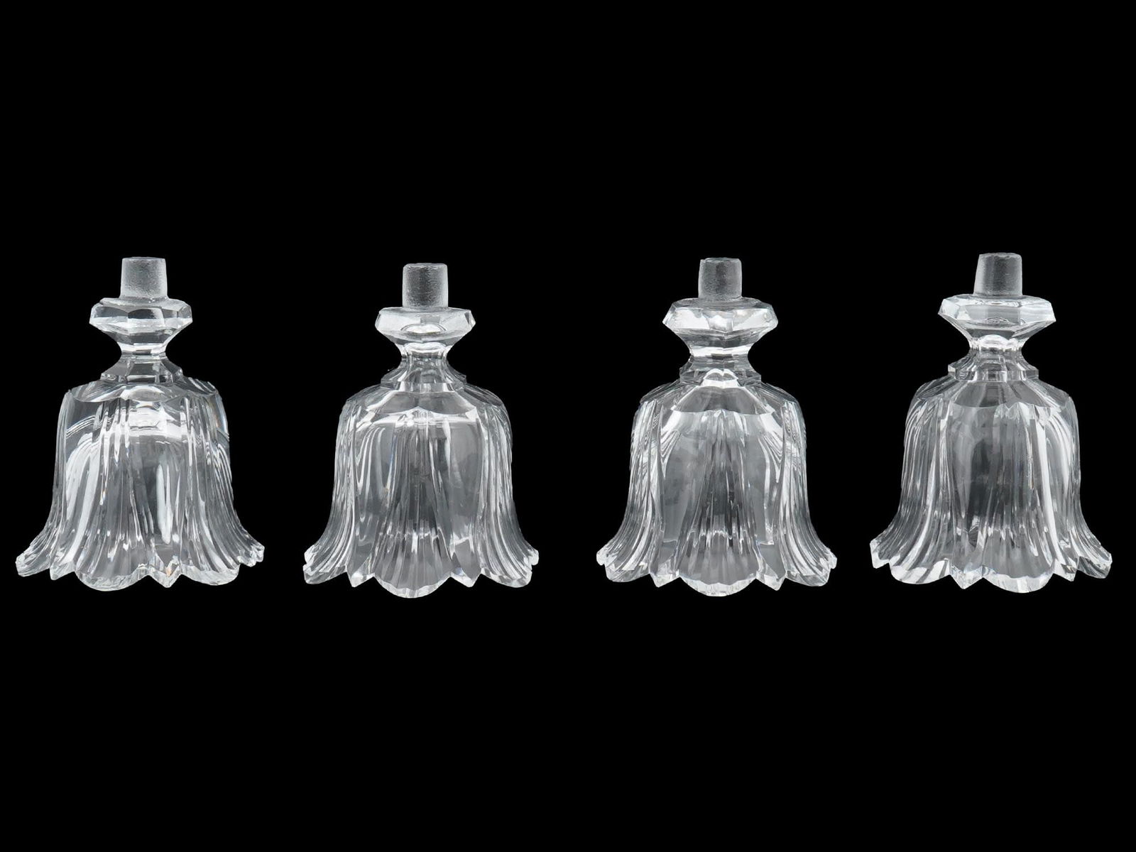 LOT OF FOUR CLEAR CUT GLASS FLORAL SHAPED PIECES: A lot of four clear, crystal glass pieces, possibly shades or parts of a chandelier or light fixture. They have a floral like shape with fluted designs and a small stem or fitting at the top. Vintage