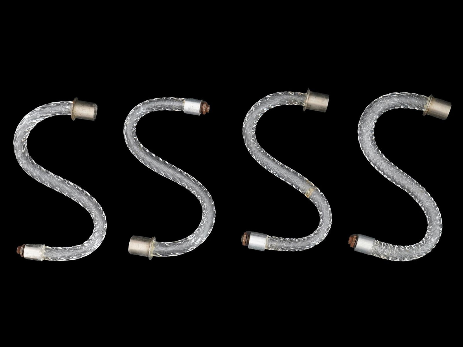 LOT OF FOUR CURVED GLASS LIGHTING FIXTURE PARTS: A lot of four clear glass tubes, each bent into an S shape. They have a twisted design within the glass, and each has a metal fitting on both ends. The glass appears to be a decorative or functional c