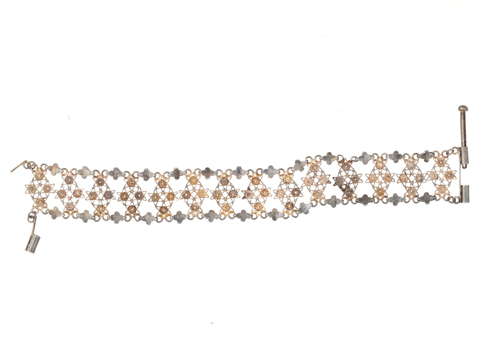 ORIENTAL MANNER GOLD AND SILVER TONE METAL BRACELET: An Oriental manner gold and silver tone metal bracelet. The bracelet is adorned with star, geometrical and swirl ornaments with pierced through accents. Unmarked. Vintage Metal Bracelets, Costume Jewe