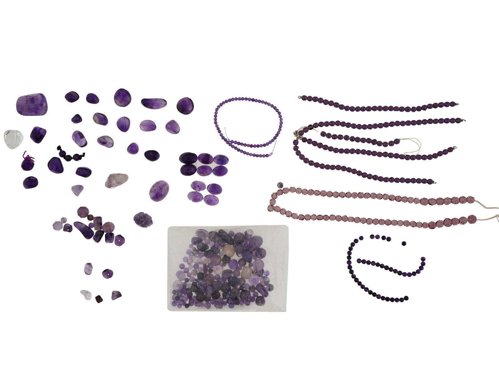 COLLECTION OF VARIOUS AMETHYST BEADS FOR JEWELRY: A collection of amethyst beads in various shapes, sizes, and shades of purple. Some of the amethysts are loose, while others are strung into necklaces or partially completed strands. The arrangements