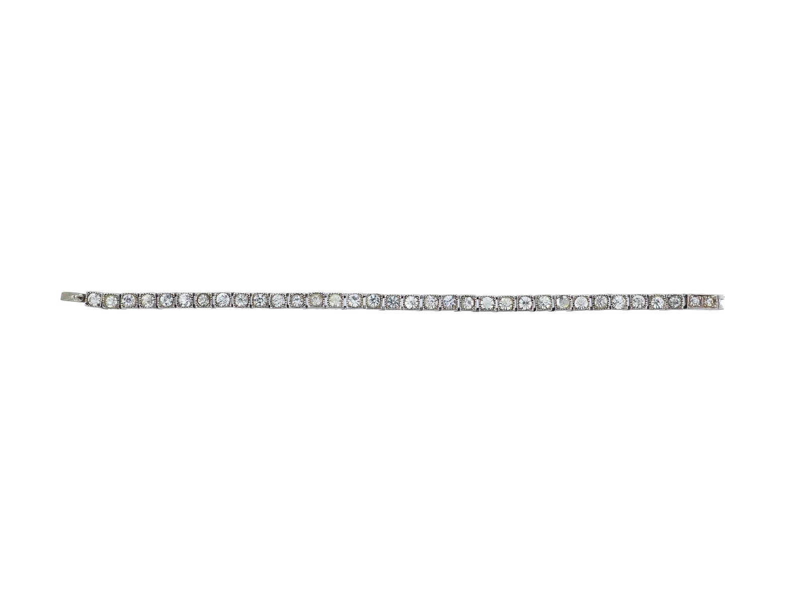 STERLING SILVER DIAMONDS TENNIS JEWELRY BRACELET: A Sterling Silver tennis jewelry bracelet. The bracelet is encrusted with faux diamonds. Marked with a Sterling Silver standard hallmark, on a clasp. Vintage and Modern Ladies Jewelry Wares and Access