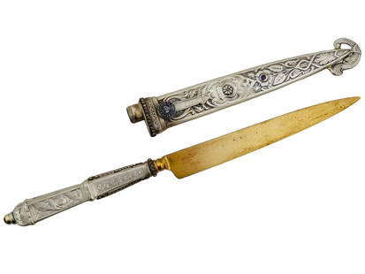 RUSSIAN 84 SILVER DIAMOND AND GARNET LETTER OPENER: A Russian 84 silver, diamond, and garnet letter opener knife with a scabbard. The letter opener features a gilt straight blade. The well detailed handle is decorated with relief foliate motifs and set
