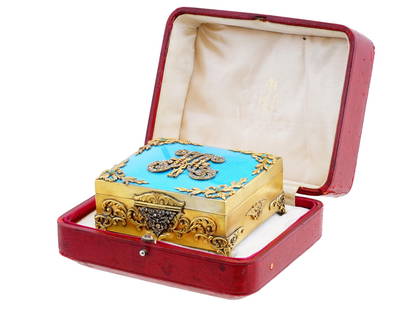 RUSSIAN IMPERIAL GILT SILVER ENAMEL BOX WITH DIAMONDS: A Russian gilt silver box on four feet. The hinged lid is adorned with blue enamel made in guilloche technique and floral decorations at the corners. Features the diamond-set monograms of Russian Empe