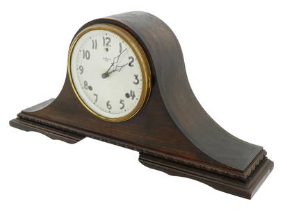 ANTIQUE 1807 AMERICAN GILBERT WOODEN MANTEL CLOCK: An antique American wooden mantel clock by the Gilbert Clock Factory. The clock is dark brown with a rounded shape and a face with Arabic numerals. Marked on the dial: Made by Gilbert 1807. Bears a pa