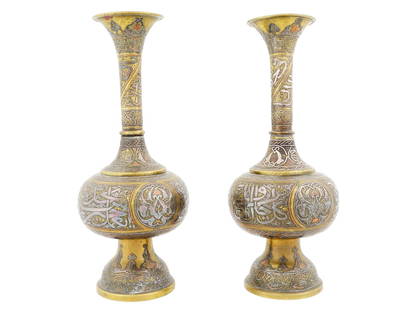 PAIR OF ARABIC SILVER AND BRASS INLAID VASES: A pair of Arabic Damascus mixed metals brass over copper and silver inlaid vases. The exterior of the vases are adorned with engraved traditional designs, foliage, and calligraphy motifs. Antique Arab