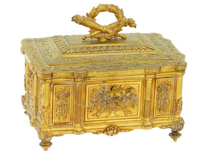 ANTIQUE 19 C FRENCH GILT BRONZE JEWELRY BOX: An antique 19th-century French gilt bronze jewelry box with key lock. Footed piece in Louis XVI style, elaborate relief ornamentation. The hinged lid is embellished with a laurel wreath finial. The in