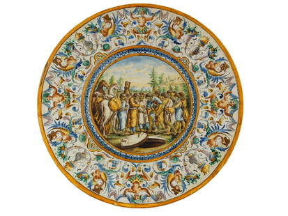 19 C MAJOLIKA JOSEPH AND HIS BROTHERS CERAMIC CHARGER: An antique Italian Renaissance Revival majolica hand painted plate or charger. The ware is adorned with a colorful figural scene of Joseph and his brothers by the well in the center and fantastic figu