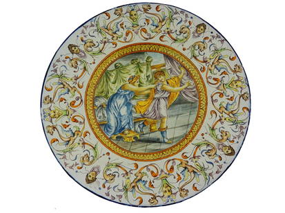 ANTIQUE ITALIAN JUDAICA HAND PAINTED MAJOLICA PLATTER: An antique Italian Judaica Majolica hand painted porcelain platter. The ware is adorned with a hand painted Judaica scene with Joseph and Potiphars Wife. Surrounding the central motif is a designed bo