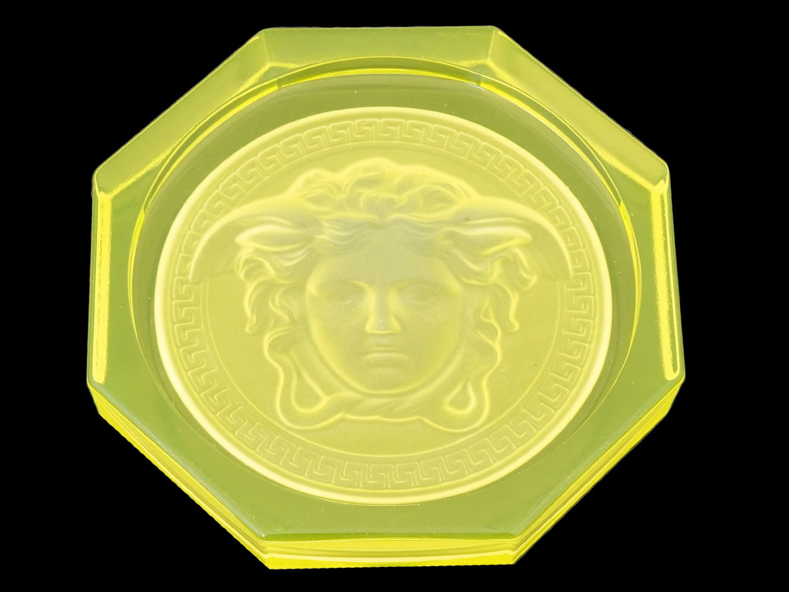 VERSACE ROSENTHAL MEDUSA YELLOW GLASS COASTER ASHTRAY: A Versace Rosenthal Medusa yellow glass coaster or ashtray. Circa: 2000s. The ware features the iconic Medusa pattern in vibrant yellow. The coaster is made of high quality uranium, vaseline glass. Ma