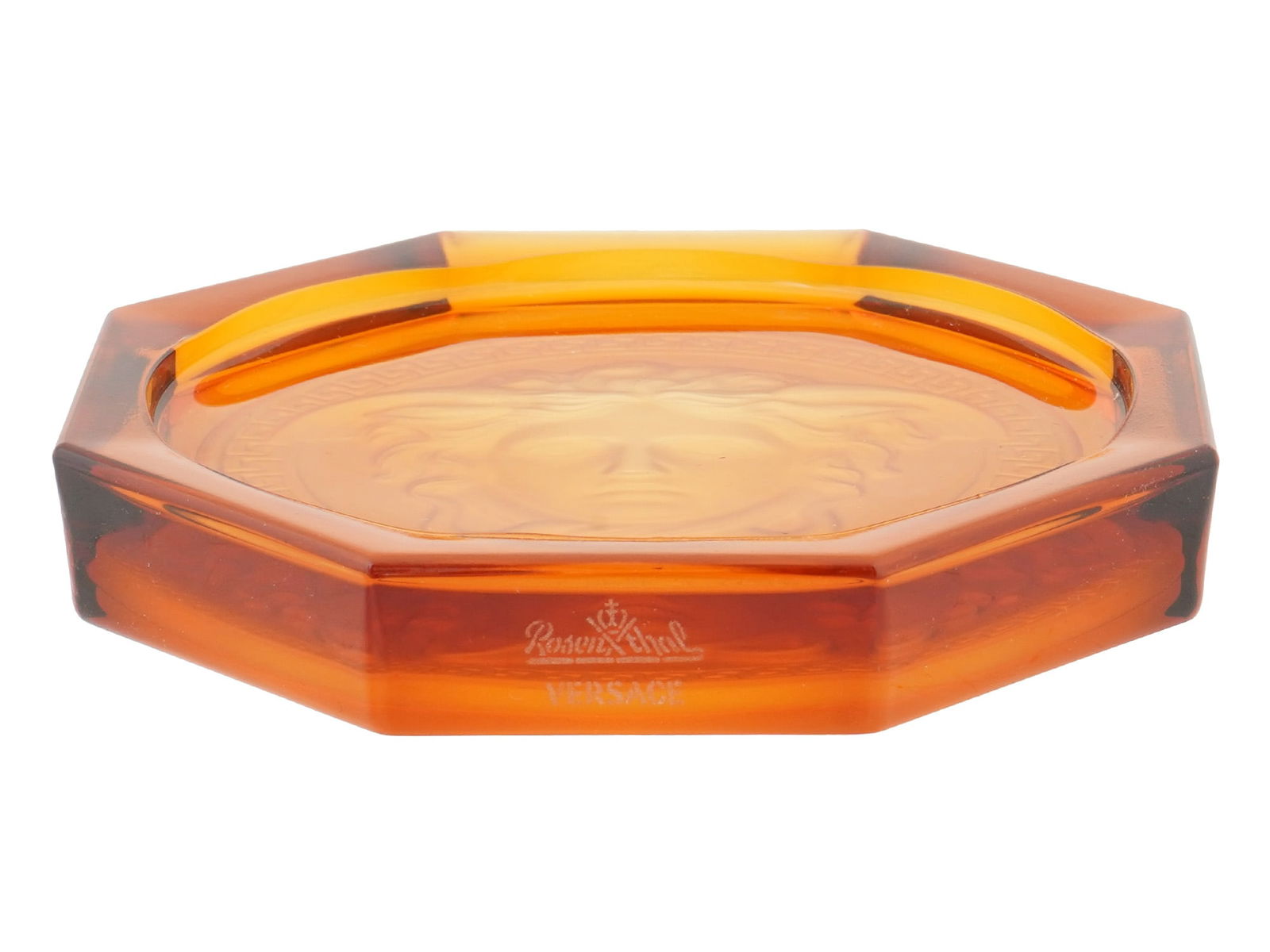 VERSACE ROSENTHAL MEDUSA ORANGE GLASS COASTER ASHTRAY: A Versace Rosenthal Medusa orange glass coaster or ashtray. Circa: 2000s. The ware features the iconic Medusa pattern in vibrant orange. The coaster is made of high quality uranium, vaseline glass. Ma