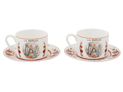 CHRISTIAN DIOR TAROT COLLECTION PORCELAIN CUPS SAUCERS: A pair of French porcelain cups with matching saucers from the Tarot Collection by Christian Dior. Each cup features the hand-painted design titled La Papesse, The High Priestess, inspired by the symb