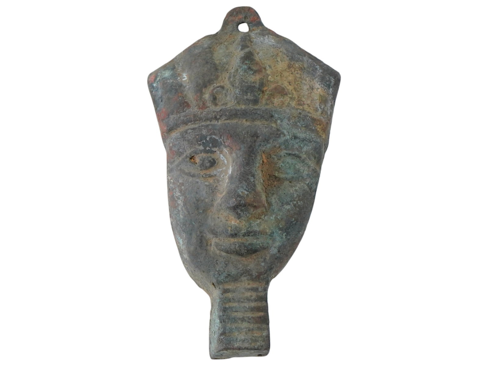 ANCIENT EGYPTIAN BRONZE INLAY HEAD OF RULER PENDANT: An ancient Egyptian Late Kingdom inlaid bronze pendant. The pendant prominently showcases the stylized face of a ruler, adorned with a headdress characteristic of ancient royalty, engraved with detail