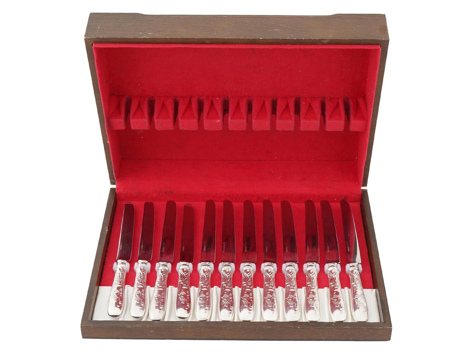 SET OF TIFFANY SILVER KNIVES IN AUDUBON PATTERN: A set of 12 American Tiffany and Co. silver knives in Audubon pattern, presented in a wooden box. The knives are arranged neatly in a row within the box, which is lined with red velvet. The knives hav