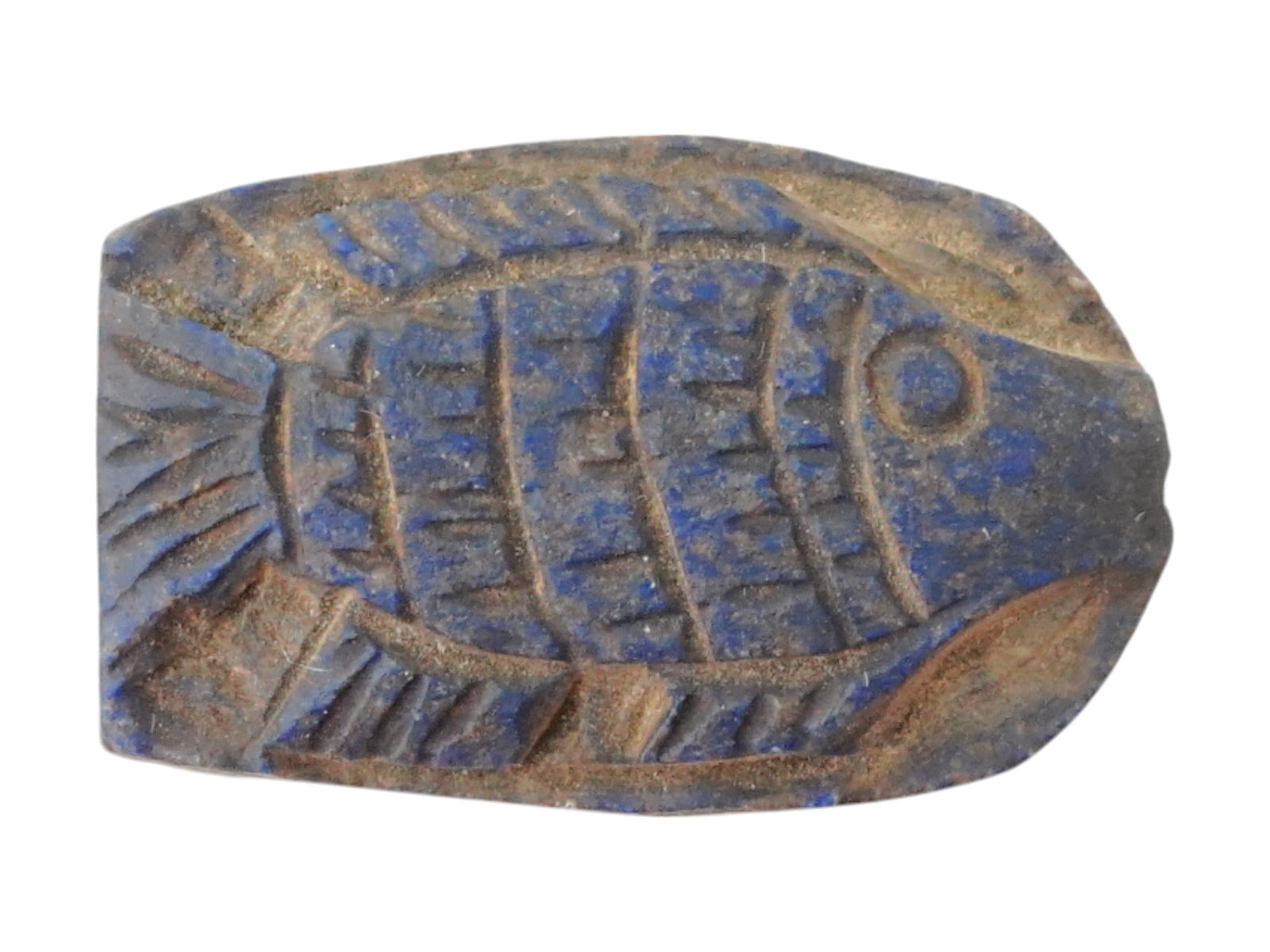 ANCIENT EGYPTIAN CARVED LAPIS LAZULI FISH AMULET: An ancient Egyptian Ptolemaic Dynasty carved Lapis Lazuli amulet pendant. The pendant is engraved with a fish design. Circa: 305 to 30 BC. An opening for wearing. Ancient Carved Natural Stones Pendant