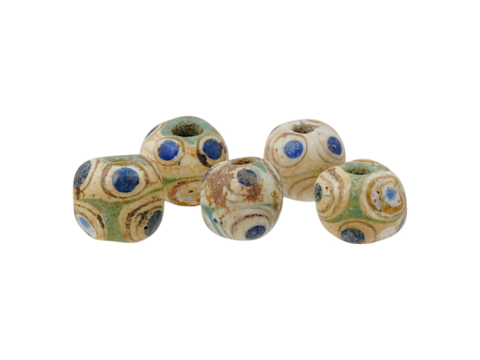 FIVE ANCIENT PHOENICIAN ROUNDED FUSED GLASS BEADS: A group of five ancient Phoenician rounded fused glass beads, dating to circa 500 to 300 BC. Each bead is individually crafted with characteristic colorful swirling designs and layered glasswork, disp