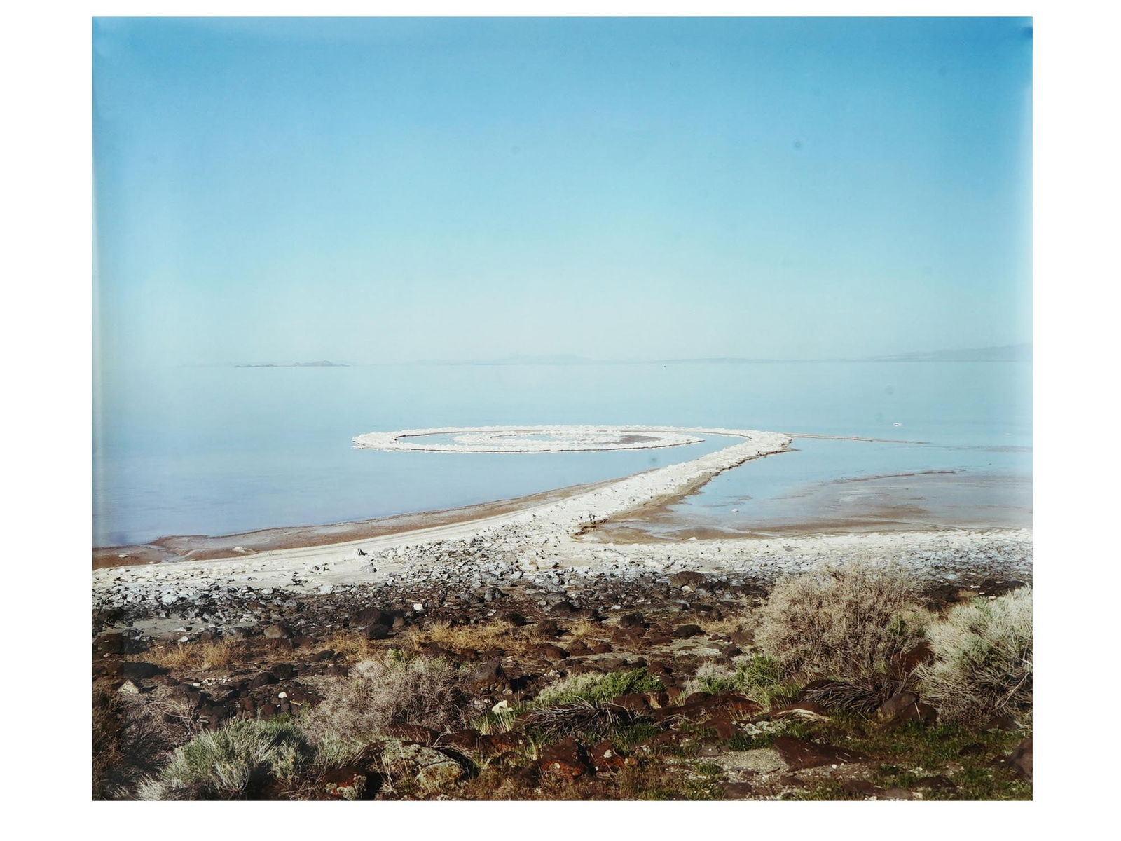 JESSICA AUER AFTER ROBERT SMITHSON SPIRAL JETTY PRINT: Color print on paper by Jessica Auer, a contemporary Canadian visual artist based in Iceland whose work is concerned with the study of landscapes as cultural sites. The artwork is a photograph of the