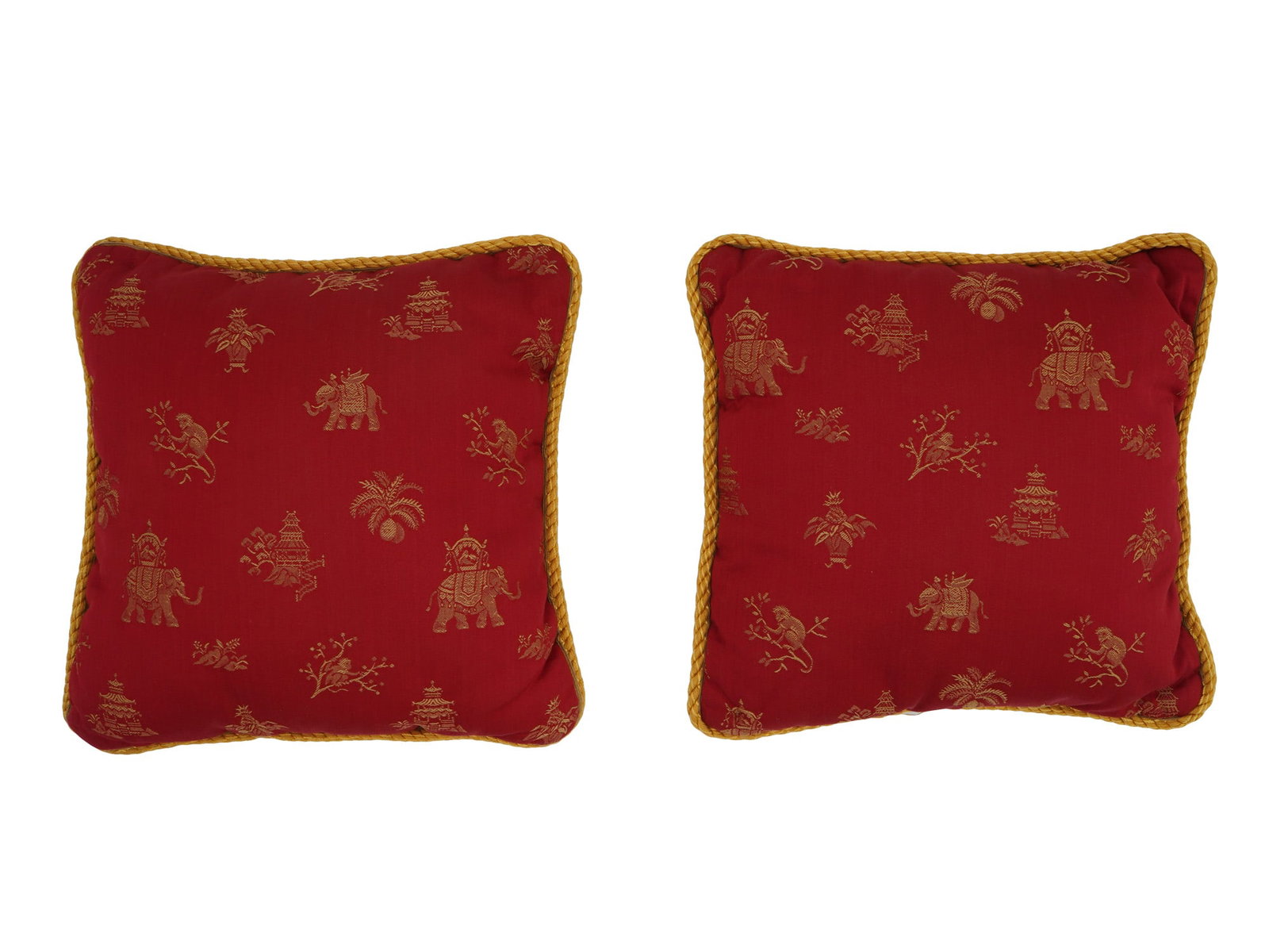 TWO SCALAMANDRE PETIT PILLOWS IN INDIAN STYLE: A lot of two Scalamandre petit pillows in Indian style. The pillows are square shaped and feature a red background with a gold toned embroidered pattern consisting of elephants, monkeys, trees, and pa