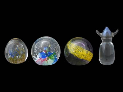 FOUR VINTAGE GLASS PAPERWEIGHTS OF VARIOUS DESIGNS: A group of four vintage glass paperweights of various shapes, each featuring inner painted decoration. The designs showcase intricate artistry and craftsmanship, with colorful motifs captured within t