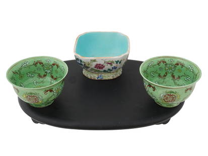 VINTAGE CHINESE PORCELAIN FLOWER MOTIF BOWLS ON A STAND: A group of vintage Chinese ceramic items, featuring two porcelain bowls with hand-painted floral designs and a Famille Rose square bowl adorned with a delicate flower motif. Each piece is marked on th