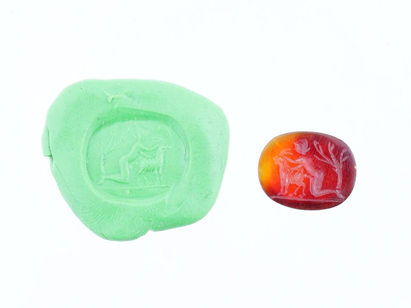 CARVED STONE INTAGLIO ANCIENT ROMAN EROTIC SCENE: A carved carnelian stone intaglio featuring a depiction of an ancient Roman erotic scene involving a man and a goat. This intricately detailed engraving reflects the artistic and symbolic traditions o