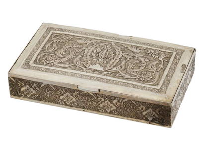 ANTIQUE PERSIAN HAND CHASED AND EMBOSSED SILVER BOX: An antique Persian hand chased and embossed silver box. The rectangular box is heavily adorned with intricate designs featuring floral patterns and birds on the hinged lif and borders. Hallmarked on t